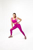 femme dans vibrant rose des sports tenue avec courbé jambe et main penché sur il photo