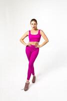 femme dans vibrant rose des sports tenue avec mains sur les hanches photo