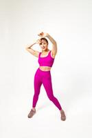 femme dans vibrant rose des sports tenue avec main élargi vers caméra photo