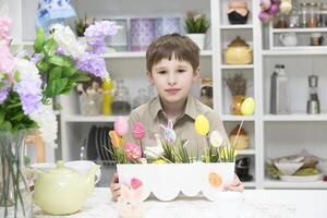 bébé dans le cuisine avec Pâques des œufs photo