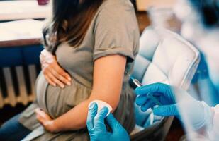 une Enceinte femme fait du une vaccination. sélectif se concentrer. médecin. photo