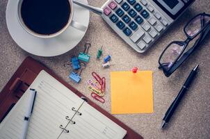 Remarque mis sur le table et une tasse de café Bureau Provisions sur le tableau. photo