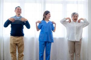 portrait de personnes âgées souriant asiatique femme et gens aérobie dans garderie maison. les personnes âgées sont en mouvement leur corps bras et épaules pour une en bonne santé vie. retraité gens Activités groupe concept. photo