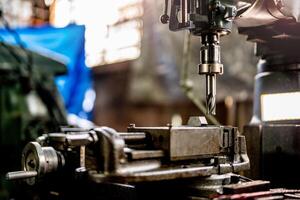 proche en haut métal percer bit rester position pour faire des trous dans acier moule. métal industrie. fraisage processus avec métal assiette les pièces sur cnc fraisage machine. magasin sol fraisage opération par fraisage machine. photo