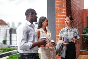 équipe de affaires gens intelligent homme et femmes supporter à Extérieur terrasse bâtiment et parler ensemble avec petit déjeuner nourriture et café sur le main dans bien sentiment avec ville espace bâtiment. affaires Matin. photo