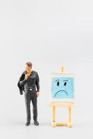 miniature personnes, une abattu homme d'affaire est positionné dans de face de une blanc conseil, bleu Lundi concept photo