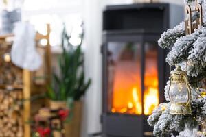 metall noir poêle, brûlant foyer cheminée dans blanc de fête intérieur de maison est décoré pour Noël et Nouveau année, Noël arbre. bois de chauffage dans le tas de bois, confortable et chauffage de Accueil photo