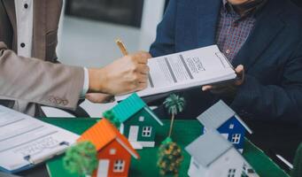 l'agent de courtage immobilier livre un échantillon d'une maison modèle au client, un contrat de prêt hypothécaire fait un bail et achète et vend une maison et contracte un concept de prêt hypothécaire d'assurance habitation photo