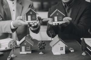l'agent de courtage immobilier livre un échantillon d'une maison modèle au client, un contrat de prêt hypothécaire fait un bail et achète et vend une maison et contracte un concept de prêt hypothécaire d'assurance habitation photo