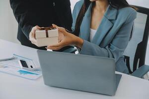 Jeune homme d'affaire donnant le sien collègue présent dans bureau. Jeune homme surprise magnifique femme d'affaires dans bureau. photo