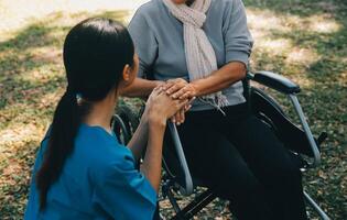 Jeune asiatique le concierge avec Années 60 Asie personnes âgées femme consultant et encourager, prendre une histoire et recommander le droite traitement à vivre Heureusement dans retraite, en portant mains et encourageant photo