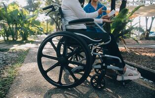 infirmière avec personnes âgées homme dans fauteuil roulant à parc photo