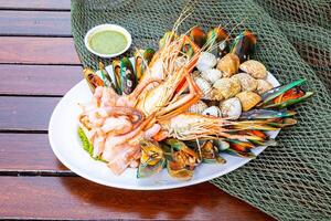 Fruit de mer crevettes, crevettes, moules, palourdes sur assiette et foncé Contexte cuit nourriture photo