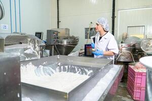 caucasion femme travail dans une nourriture usine portant protecteur vêtements et gants. photo