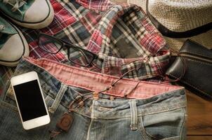 accessoire intelligent téléphone jeans chaussures, portefeuille, jeans, Chapeaux chemise sur une en bois sol pour voyage photo