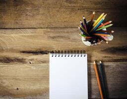 Couleur crayon et carnet de croquis sur bois table photo