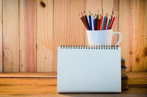 Couleur crayon et carnet de croquis sur bois table photo