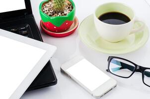 téléphone intelligent, des lunettes sur le bureau avec une portable et café Coupe. photo