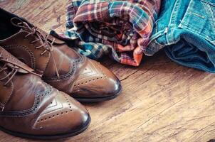 équipement, vêtements, jeans, chemises, des chaussures sur le en bois sol. photo