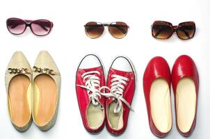 mis des chaussures et des lunettes de soleil sur une blanc Contexte modes - modes de vie photo