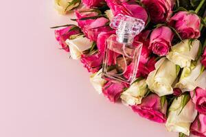 élégant floral parfum dans une transparent bouteille mensonges sur le bourgeons de Frais des roses. une copie espace. parfum et beauté concept photo