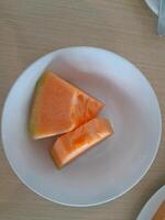 tranches de melon sur une blanc assiette photo