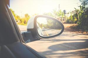 vue arrière miroir voiture dans le réflexion forêt et longue chaussée photo