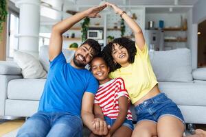 Nouveau bâtiment Résidentiel maison achat appartement concept.portrait de une Jeune famille formant toit avec leur mains à Nouveau Accueil photo