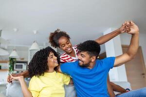 content famille jouer ensemble sur canapé à maison.mère père et enfant fille profiter content se détendre dépenses temps ensemble dans moderne vivant pièce dans soir. photo