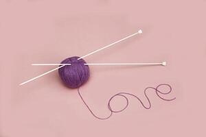 tricot aiguilles avec violet fils et le mot l'amour photo