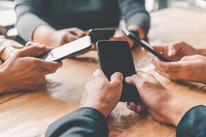 gens groupe mains sont en jouant mobile dans groupes à le surf le social en ligne monde. photo