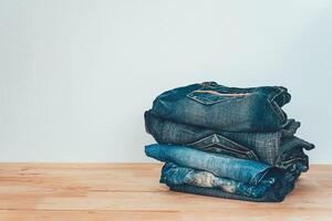 pile de jeans sur une en bois Contexte photo