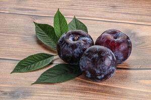 brut violet prunes tas avec feuilles photo