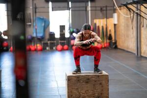 femme squat sur une boîte dans une Gym après sauter photo