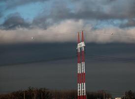 haute Tension tours avec électrique fils sur foncé nuageux ciel Contexte. photo