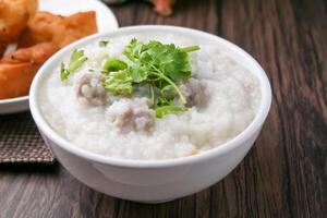 proche en haut riz bouillie ,congé avec haché porc et gingembre dans blanc bol photo