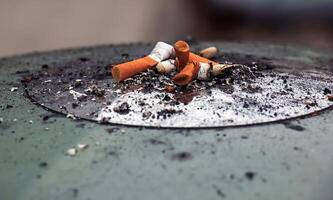 cendrier avec cigarette mégots et cendres. anti-tabac concept. photo