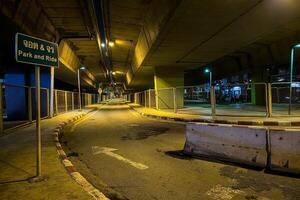 paysage de en dessous de dépasser pont à nuit. Traduction thaïlandais texte sur signe est parc et conduire. photo