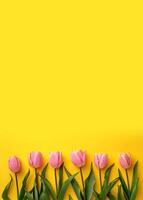 ai généré rose tulipes sur Jaune arrière-plan, Haut voir. espace pour texte photo