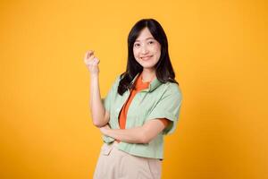 de bonne humeur asiatique femme 30s portant vert et Orange chemise. avec franchi bras, dégage confiance en soi et équilibre. parfait pour capturer le essence de confiance et mettant en valeur une vibrant mode concept. photo