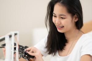 portrait de adolescent les filles élèves en train d'étudier avec main robot modèle dans le vivant pièce photo