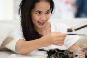 portrait de adolescent les filles élèves en train d'étudier avec main robot modèle dans le vivant pièce photo