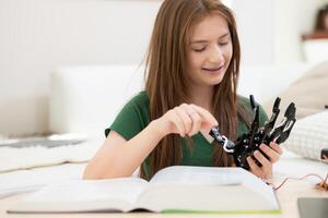 portrait de adolescent les filles élèves en train d'étudier avec main robot modèle dans le vivant pièce photo