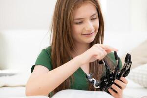 portrait de adolescent les filles élèves en train d'étudier avec main robot modèle dans le vivant pièce photo