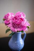 magnifique Frais rose pivoines dans une cruche bleu cruche photo