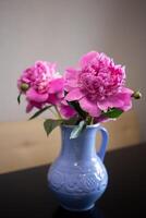 magnifique Frais rose pivoines dans une cruche bleu cruche photo