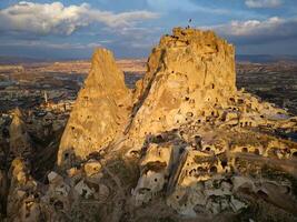 aérien drone vue de le uchisar Château dans cappadoce, dinde pendant le coucher du soleil. cette grand Roche volcanique affleurement est un de la cappadoce plus important Repères. photo