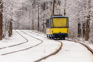 un vieux tramway se déplaçant dans une forêt d'hiver photo