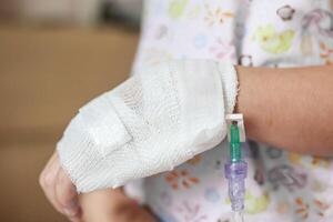 proche en haut enfant main avec saline iv Solution dans hôpital photo