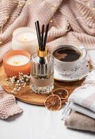 bambou des bâtons dans bouteille avec parfumé bougies et tasse de café photo